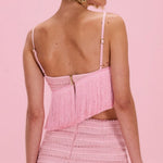 Woman wearing a pink crochet set against a pink background
