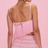 Woman wearing a pink crochet set against a pink background
