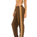 Brown sweatpants with shade of brown stripes worn by a person on a white background