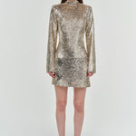 Woman wearing a gold sequin dress on a white background
