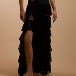 Black lace skirt worn by a person on a beige background
