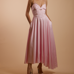 Woman wearing a pink dress with a plain background