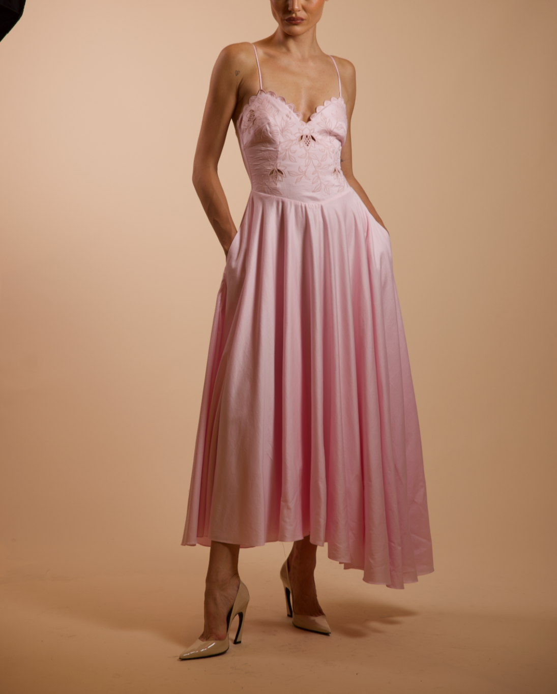 Woman wearing a pink dress with a plain background