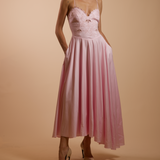 Woman wearing a pink dress with a plain background